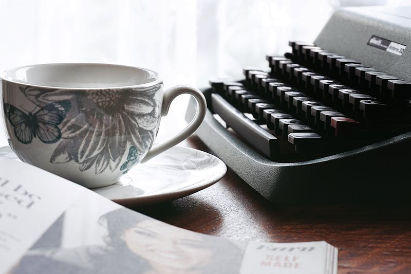 Maszyna do pisania i filiżanka na biurku